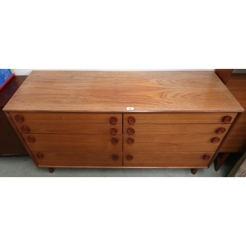 107 - A mid 20th century teak Meredew bank of eight drawers with pairs of graduating drawers on turned sup... 