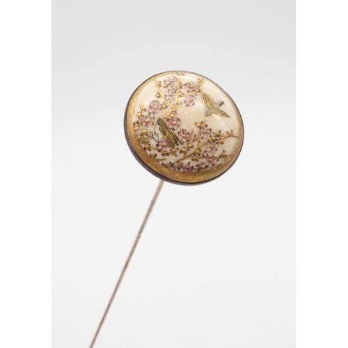 414A - A Japanese satsuma silver mounted hat pin, the roundel decorated with birds amongst a cherry blossom... 