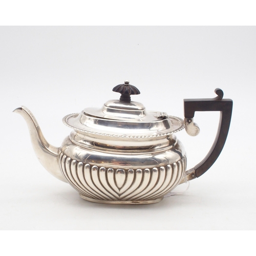 426 - A silver tea pot, the body fluted, with a gadrooned rim, an ebonised finial and handle, probably by ... 