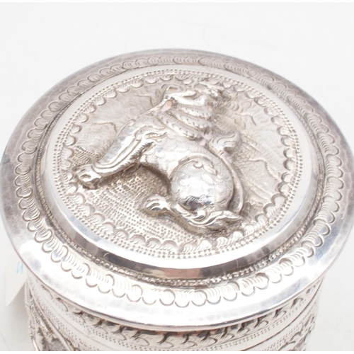 437 - A Cambodian silver betel nut box, modelled as a temple lion, an Indian white metal cylindrical box, ... 