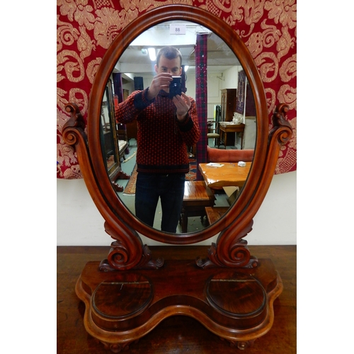 88 - A Victorian mahogany oval dressing mirror and a box of assorted brass and copper wares (2)