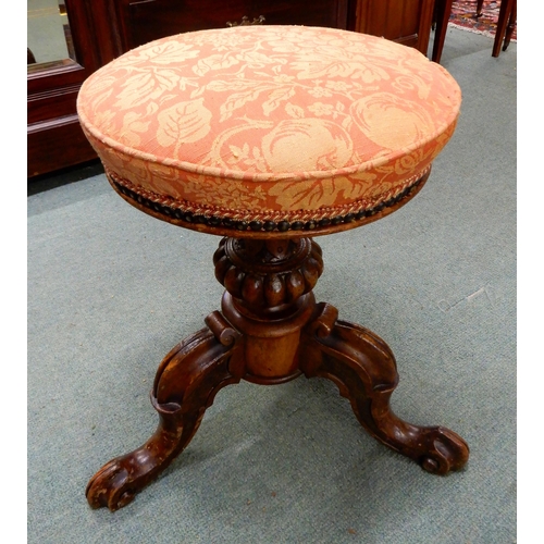 91 - A Victorian walnut adjustable piano stool with fruit and foliate upholstered seat on baluster tripod... 