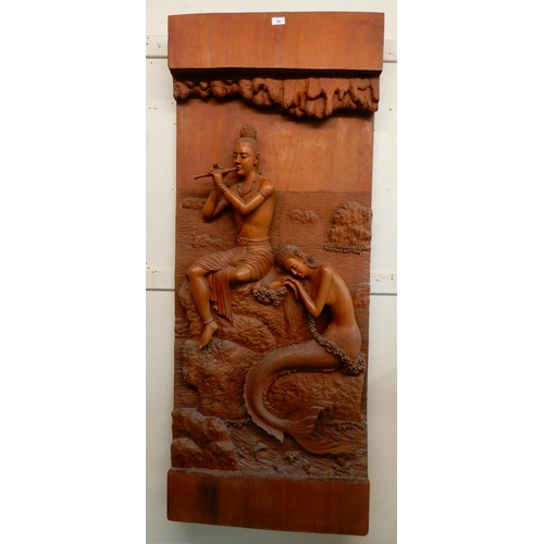 95 - A 20th century hardwood wall sculpture of a piper and a mermaid, 162cm high x 65cm wide