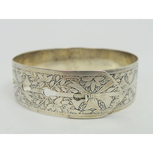 719B - A CHARLES HORNER hallmarked silver bangle in the form of a belt with adjustable buckle design fasten... 