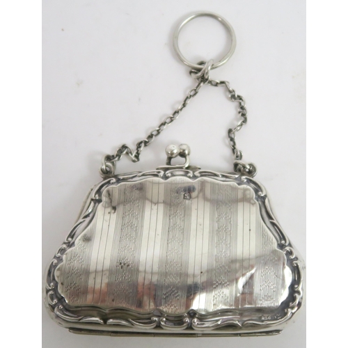 739A - A George V silver purse, the shaped body with a scrolling border, with bands of engine turned decora... 