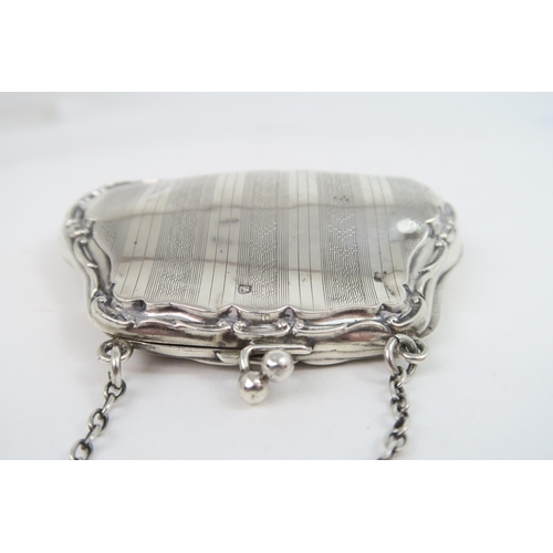 739A - A George V silver purse, the shaped body with a scrolling border, with bands of engine turned decora... 