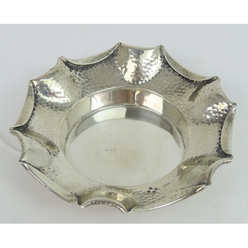 759B - A Victorian silver arts and crafts style dish, the body with a hammered finish, with a fold over pie... 