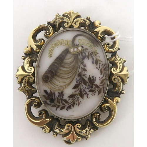 759C - A Victorian memorial hair art brooch. The scrolling yellow metal pendant brooch, has a locket to bot... 