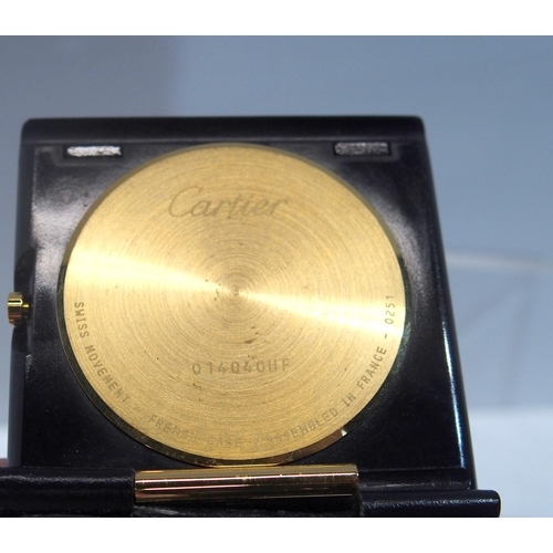 287 - A Cartier travel clock, model 0251 mounted in a black leather folding travel case, with number 01404... 