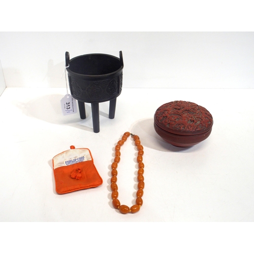 313 - A string of amber coloured beads, a red lacquered box and a metal koro on three legs