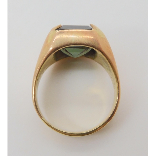 683 - A yellow metal ring, set with a green glass gem, size approx R, weight 13.1gms