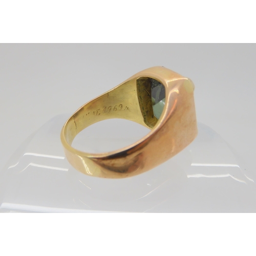 683 - A yellow metal ring, set with a green glass gem, size approx R, weight 13.1gms