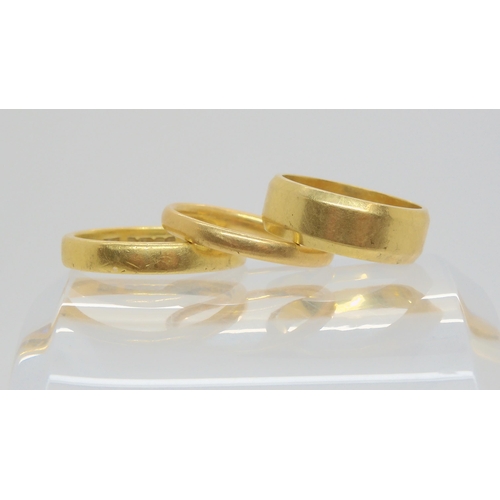 688 - Three 18ct gold wedding rings, sizes (wide) J1/2, P and M1/2, weight together 12.2gms