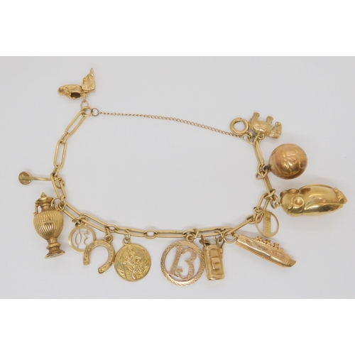 710 - A 9ct gold charm bracelet hung with thirteen 9ct gold and yellow metal charms to include  a Cha... 