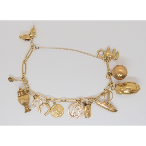 710 - A 9ct gold charm bracelet hung with thirteen 9ct gold and yellow metal charms to include  a Cha... 
