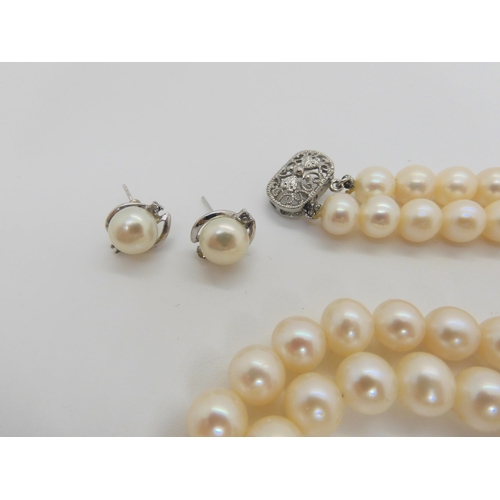 759 - A double string of large cultured pearls of slightly baroque shape with matching earrings, each pear... 