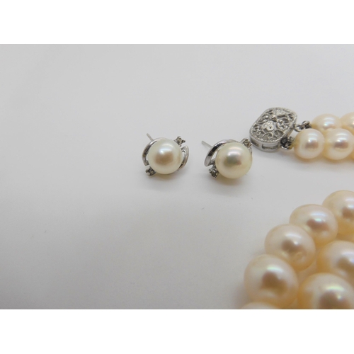 759 - A double string of large cultured pearls of slightly baroque shape with matching earrings, each pear... 