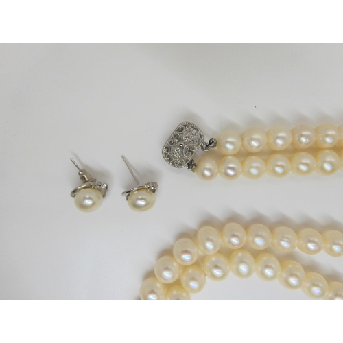 759 - A double string of large cultured pearls of slightly baroque shape with matching earrings, each pear... 