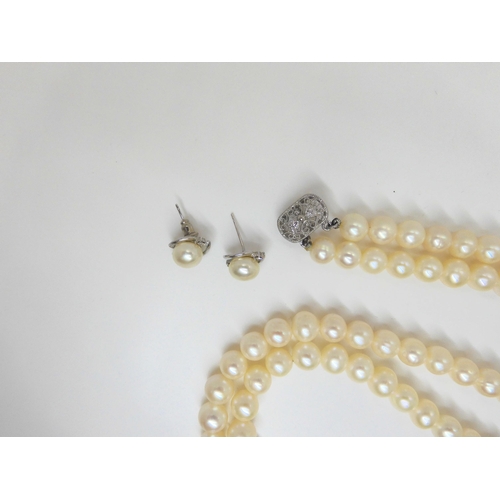 759 - A double string of large cultured pearls of slightly baroque shape with matching earrings, each pear... 