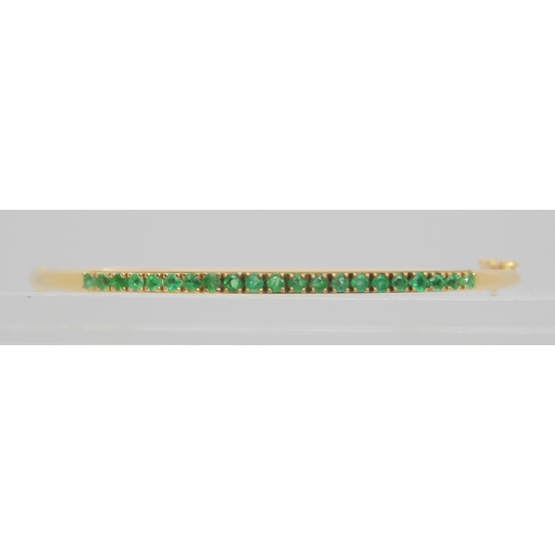 765 - A 14k gold bangle set with emeralds, inner dimensions 5.7cm x 5.2cm, weight 5.4gms