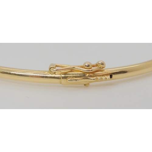 765 - A 14k gold bangle set with emeralds, inner dimensions 5.7cm x 5.2cm, weight 5.4gms