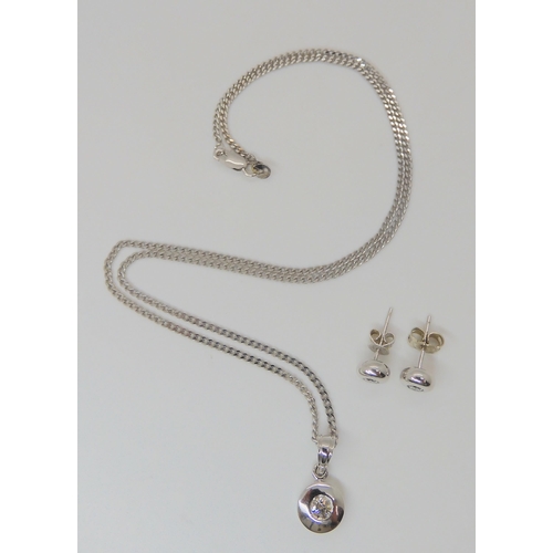 775 - An 18ct white gold pendant set with an estimated approx 0.25ct diamond, with matching earrings set w... 