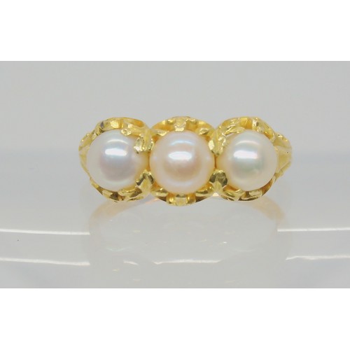 747 - A Victorian style three pearl ring, with a decorative bright yellow metal scroll mount. Size N1/2, w... 