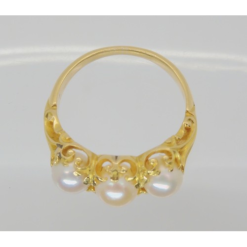 747 - A Victorian style three pearl ring, with a decorative bright yellow metal scroll mount. Size N1/2, w... 