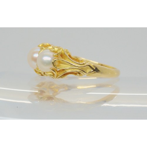 747 - A Victorian style three pearl ring, with a decorative bright yellow metal scroll mount. Size N1/2, w... 