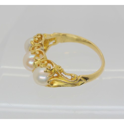 747 - A Victorian style three pearl ring, with a decorative bright yellow metal scroll mount. Size N1/2, w... 