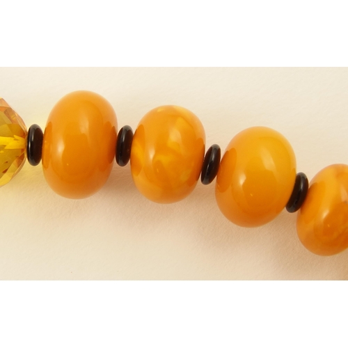 107 - Item 12. A mixed amber coloured bead necklace