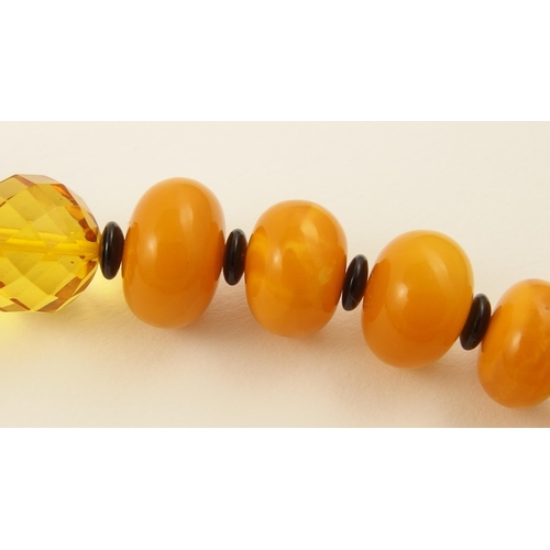 107 - Item 12. A mixed amber coloured bead necklace