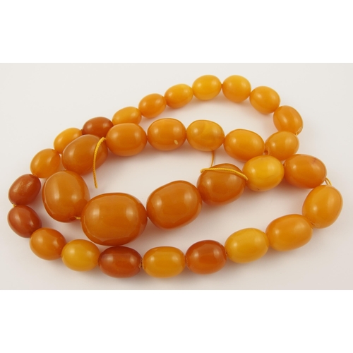 71 - A string of yellow amber coloured beads