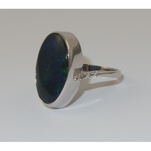 76 - An 18ct white gold ring set with a solid black opal