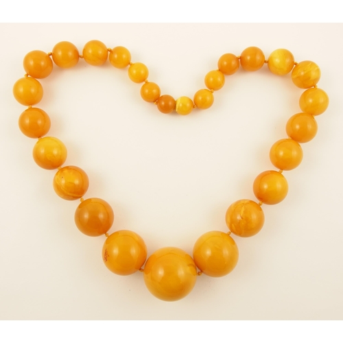 97 - Item 2. A light orange amber coloured necklace