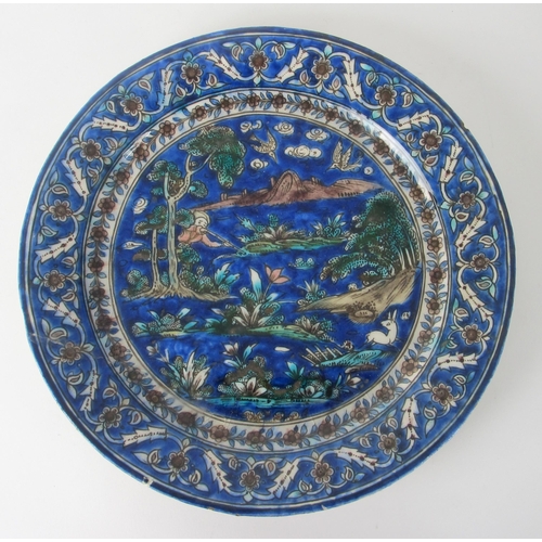 542C - A Persian moulded and painted blue ground circular dish