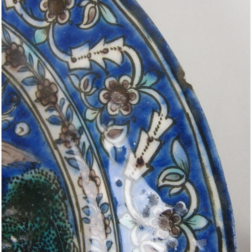 542C - A Persian moulded and painted blue ground circular dish