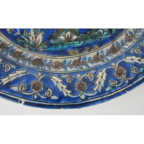 542C - A Persian moulded and painted blue ground circular dish