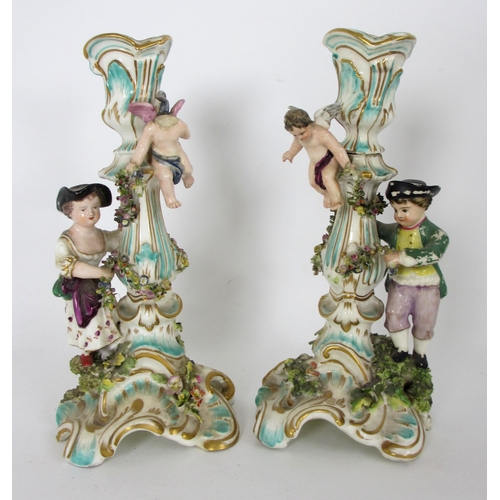 654 - A pair of Derby rococo moulded candlesticks