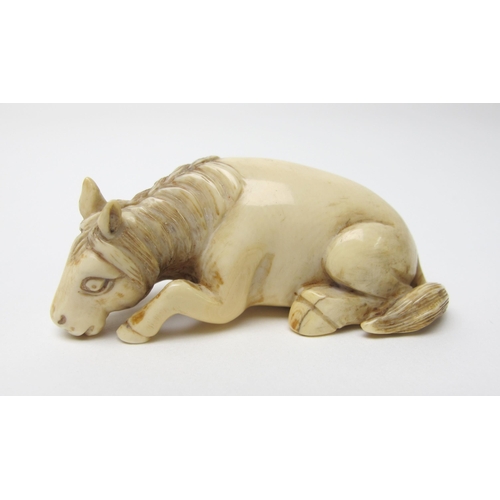 522 - A Japanese ivory netsuke of a recumbent horse