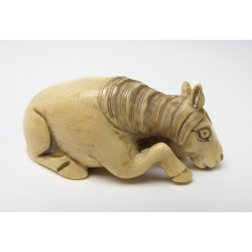 522 - A Japanese ivory netsuke of a recumbent horse