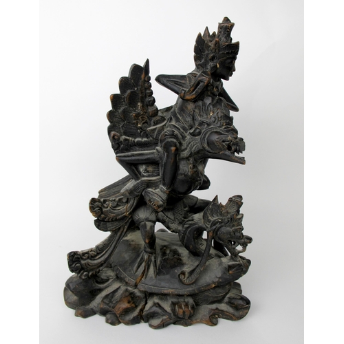 536 - An Indonesian carved and stained wood group of Garuda