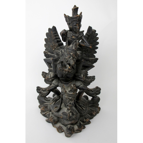 536 - An Indonesian carved and stained wood group of Garuda