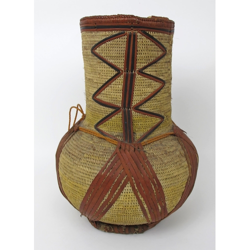 545 - An African straw and leather baluster vessel and cover