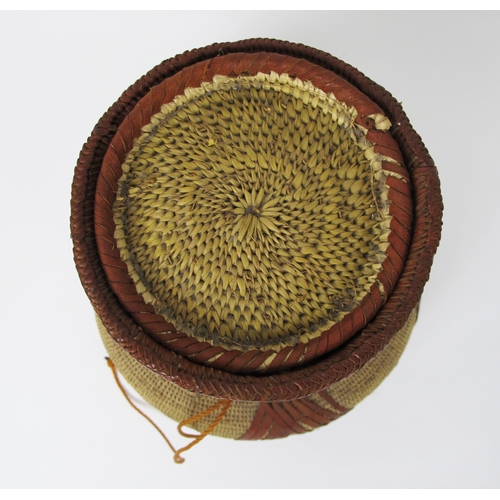 545 - An African straw and leather baluster vessel and cover