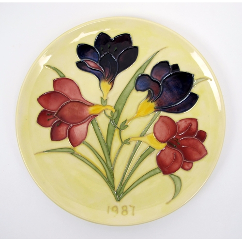 665 - A Moorcroft pottery freesia plate dated 1987