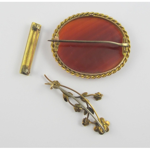 111 - A collection of three brooches  a 9ct gold mounted banded carnelian brooch  together with a seed pea... 