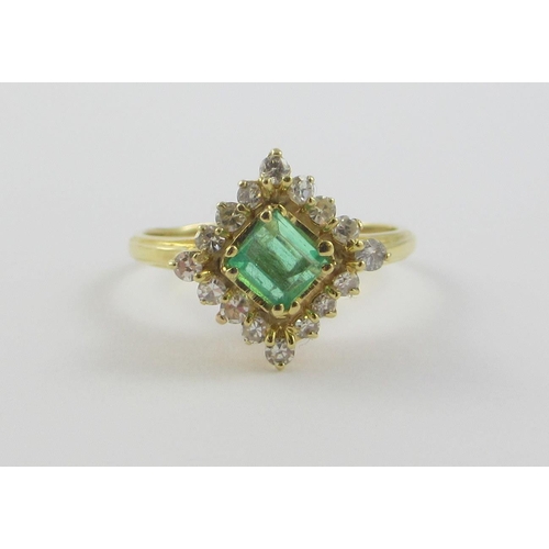 113 - An emerald and diamond ring  a square cut emerald claw set  surrounded with 16 brilliant cut claw se... 