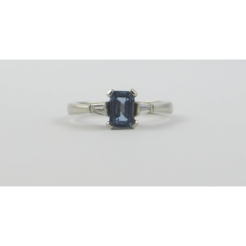 117 - A platinum sapphire and diamond ring  set with a claw set emerald cut sapphire  and tapered baguette... 