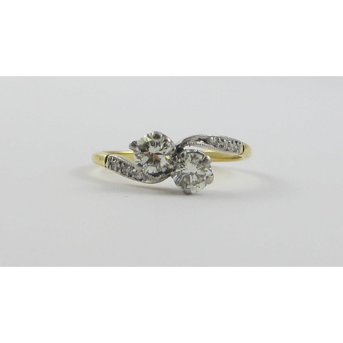 122 - A two stone diamond twist  ring of approx 0.60cts  set in 18ct yellow and white metal  with pave set... 